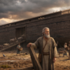 Noah stands before a massive wooden Ark as animals gather nearby and his family prepares supplies under dark storm clouds.